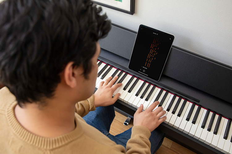 Tablet with Roland Piano App on piano music rest