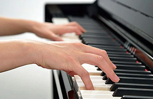 Hands playing a piano