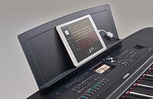 close-up image of Yamaha DGX-670 with tablet computer sitting on music rest