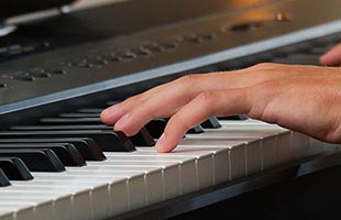 close-up image of hands playing Kawai ES920 digital piano