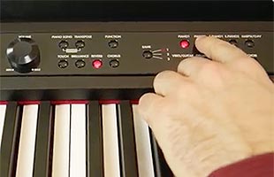 close-up view of piano player's fingers using control panel on Korg LP-380U to choose sound