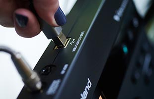 detail image of TD-07 drum sound module included in Roland TD-07DMK with drummer's hand connecting USB cable