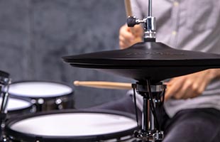 close-up image of drummer playing Roland electronic drum set with Roland VH-14D in foreground